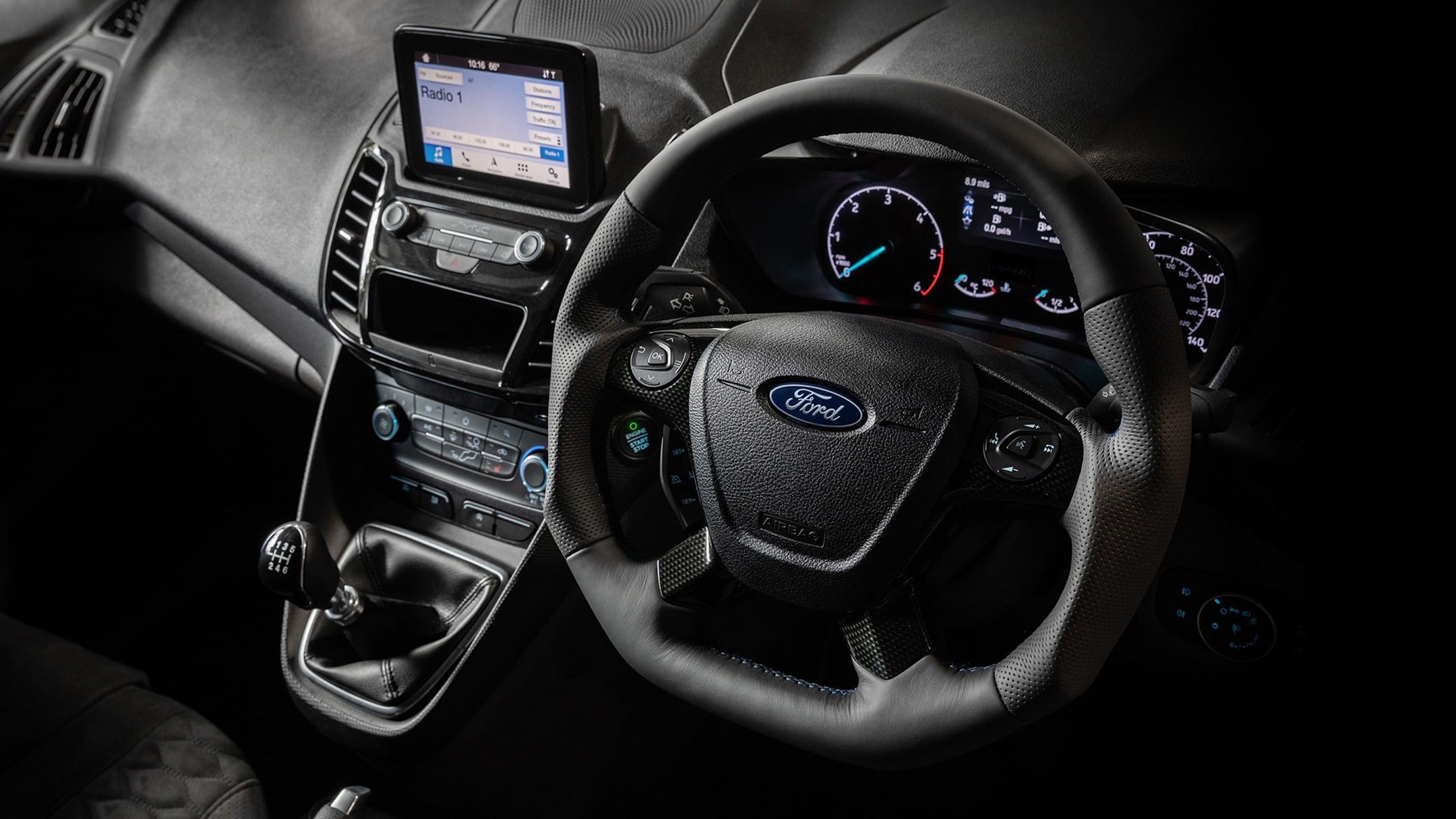 Interior view of the Ford Transit Connect MS-RT cockpit showing the steering wheel and dashboard modules. 