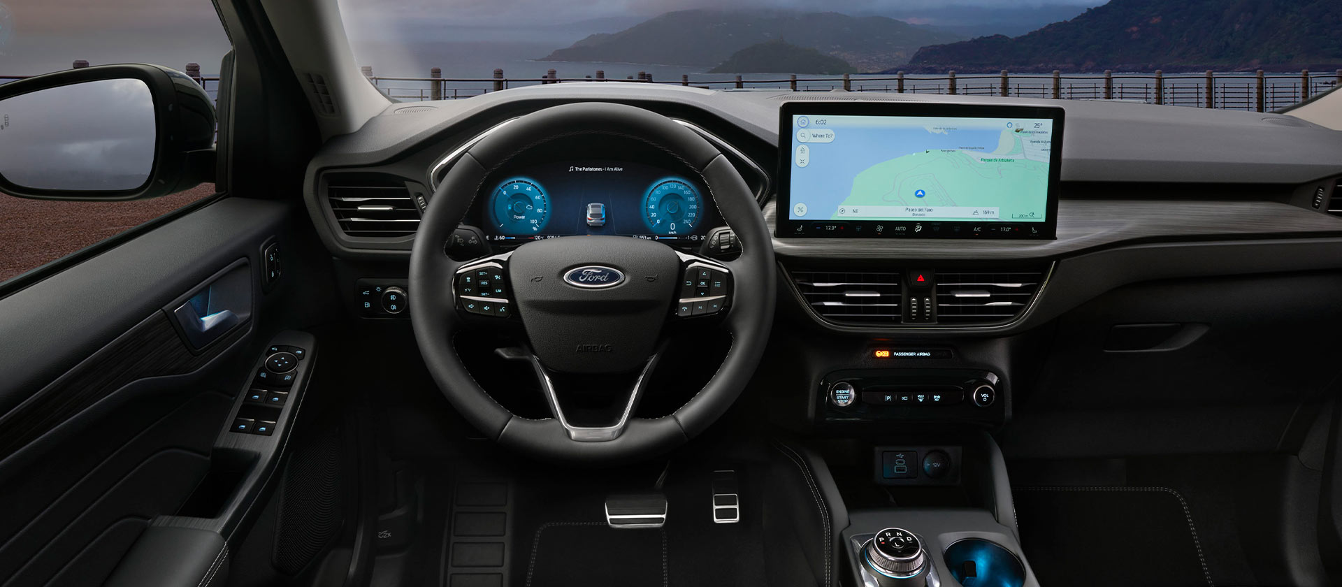 Interiorul unei mașini hibride cu încărcare automată Ford și ecran de navigație în interiorul vehiculului.
