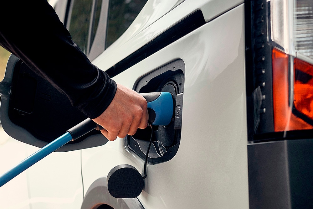 O persoană care conectează un vehicul electric Ford la un cablu de încărcare EV.