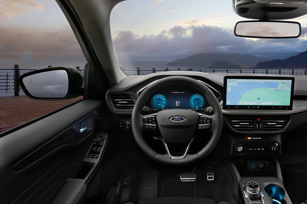 Interiorul unei mașini hibride cu încărcare automată Ford și ecran de navigație în interiorul vehiculului.