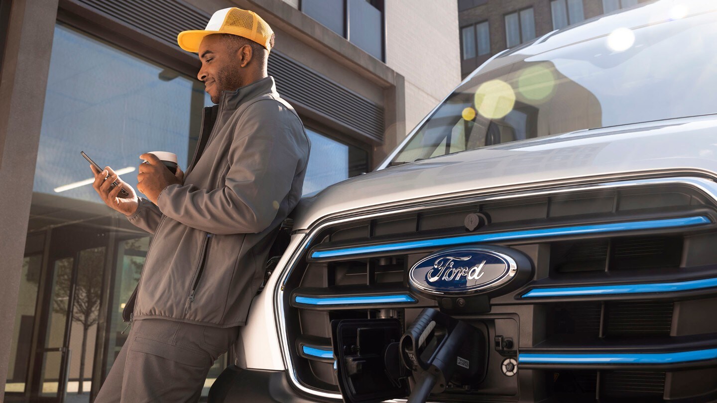 Person standing next to charging Ford Van