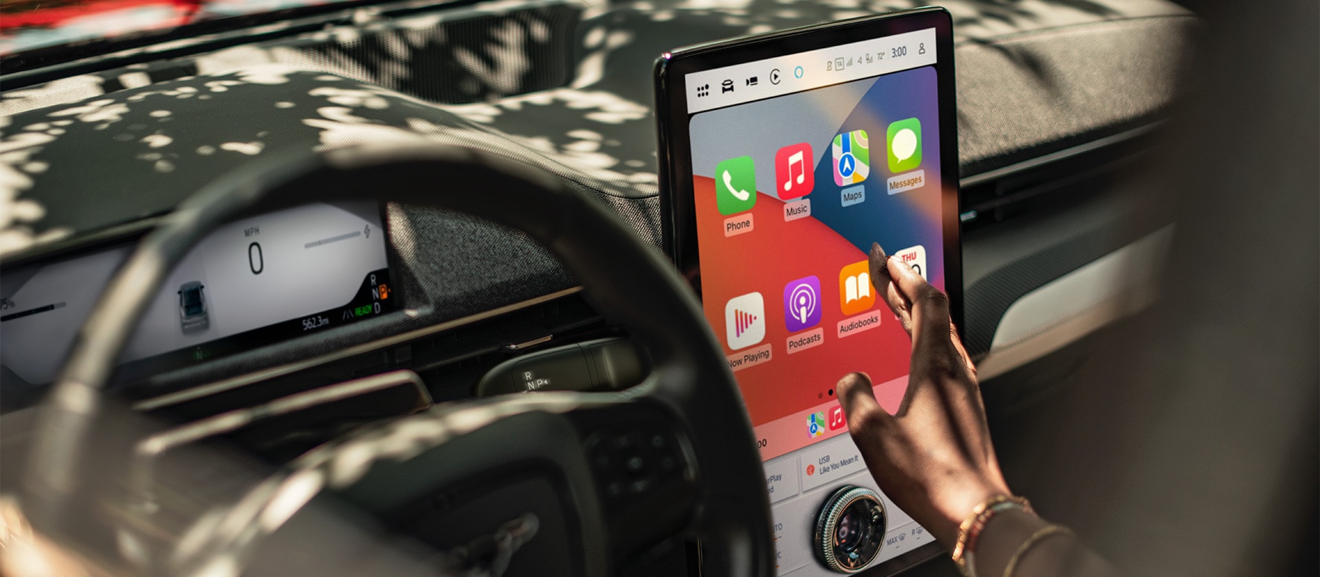 Un prim-plan cu șoferul unui vehicul Ford Mustang Mach-E care interacționează cu ecranul tactil mare de 15,5" SYNC 4 care prezintă funcția Apple CarPlay. 
