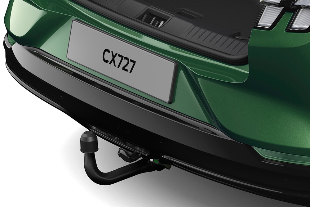 Un prim-plan cu cârligul de remorcare electric al unui vehicul Ford Mustang Mach-E verde, fotografiat în studio pe un fundal alb.