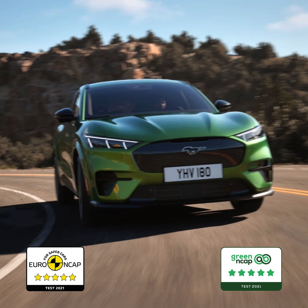 Un vehicul Ford Mustang Mach-E GT în culoarea Eruption Green pe un drum de munte.