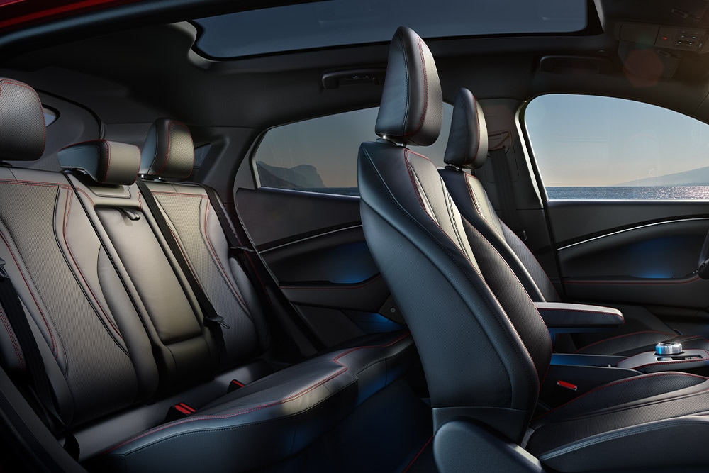 Interiorul modelului Ford Mustang Mach-E, care prezintă cele cinci scaune confortabile finisate cu material negru cu cusături roșii.