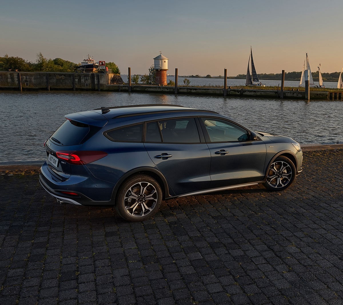 Ford Focus parked by a lake during a sunset