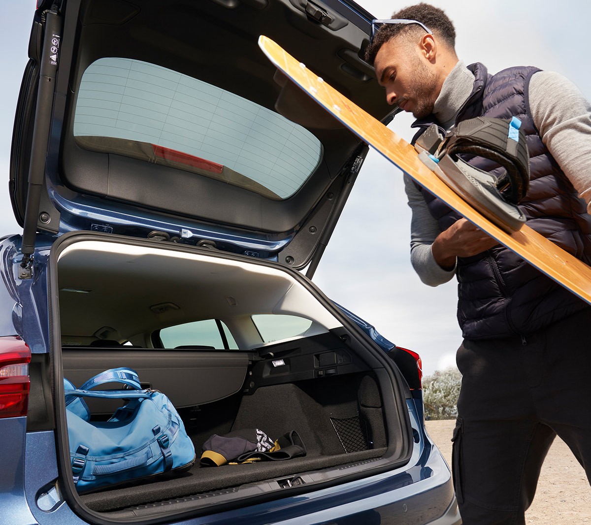 Man loading things into an open trunk of a Ford Focus