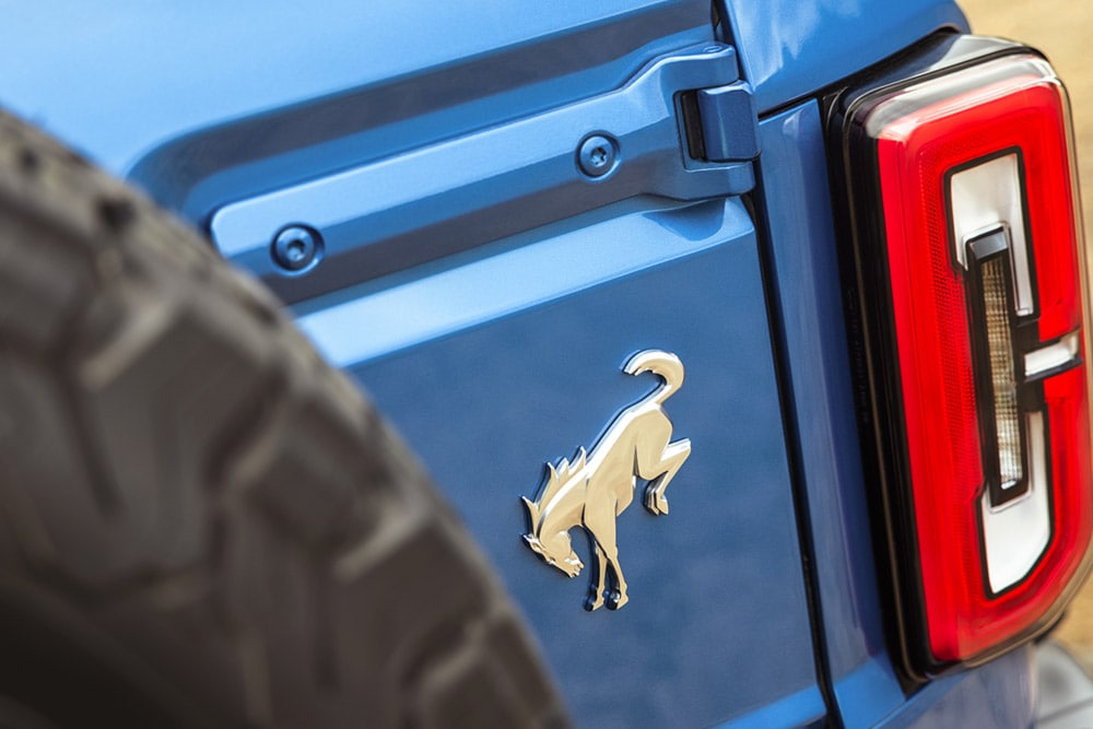 Prim-plan cu detaliile de marcă de pe spatele unui model Ford Bronco albastru.