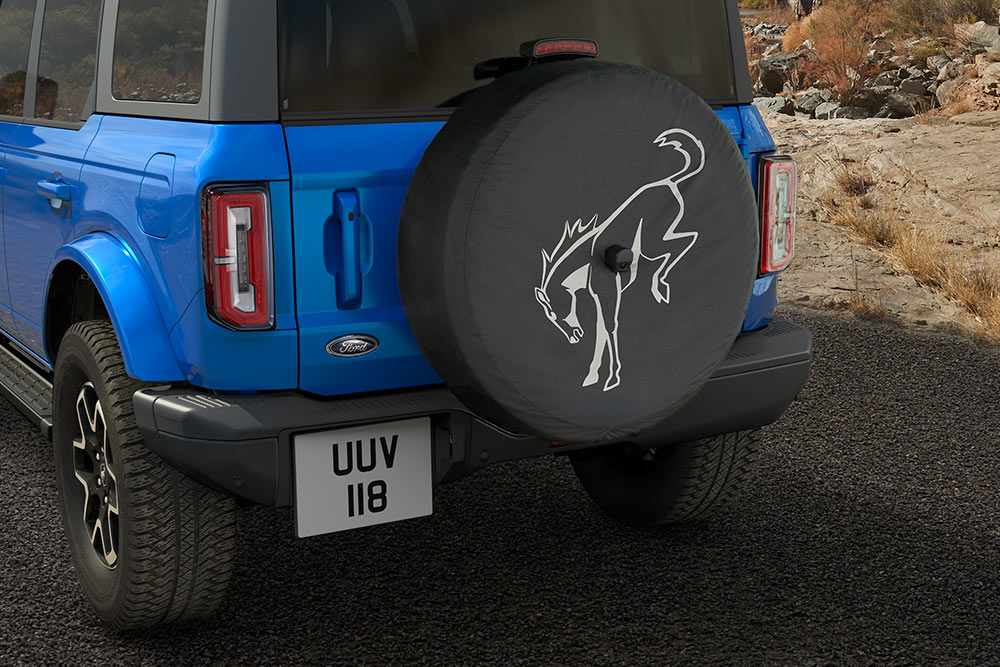Vedere din spate a unui model Ford Bronco albastru cu o anvelopă de rezervă montată pe spate.