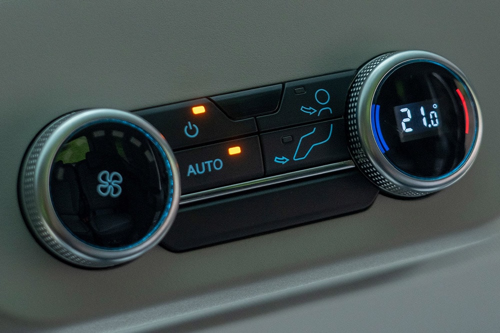 Prim-plan al cadranelor de control ale climatizării vehiculului.