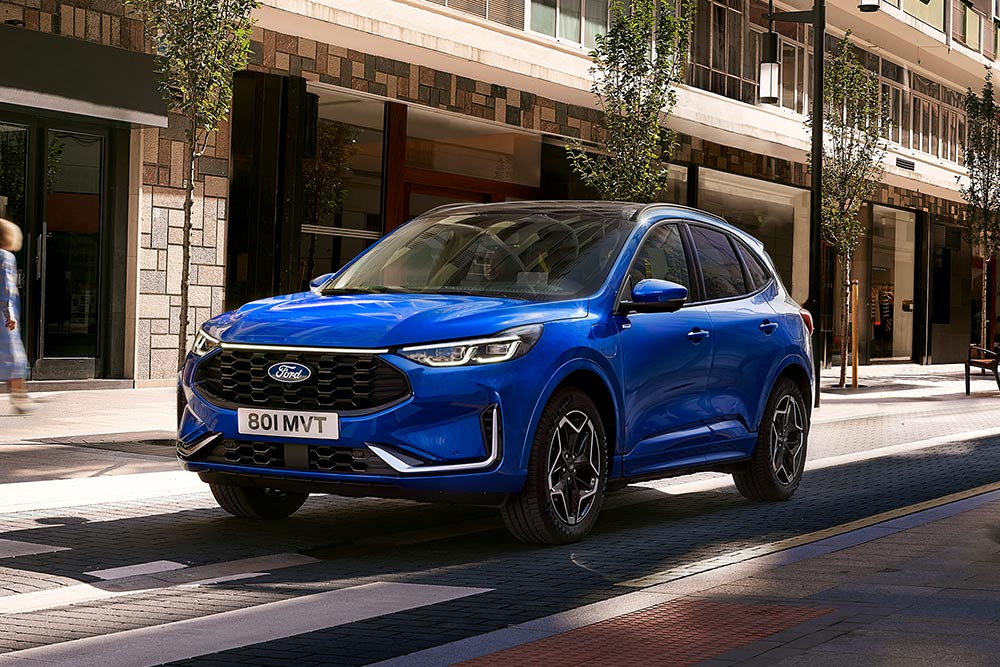 Un Ford Kuga ST Line în culoarea Desert Island Blue, parcat într-o zonă rezidențială.