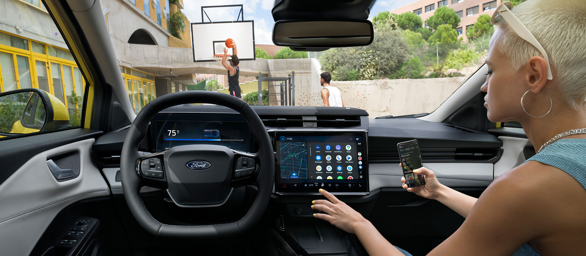 Interiorul modelului electric Ford Puma Gen-E®, cu o persoană care își sincronizează wireless telefonul cu ecranul tactil.