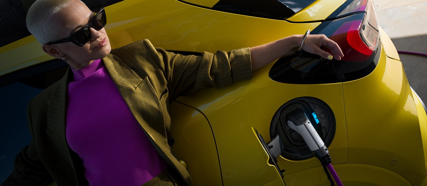 Un prim-plan cu partea din spate a Ford Puma Gen-E® electric, conectat la o priză de încărcare de perete pentru acasă.
