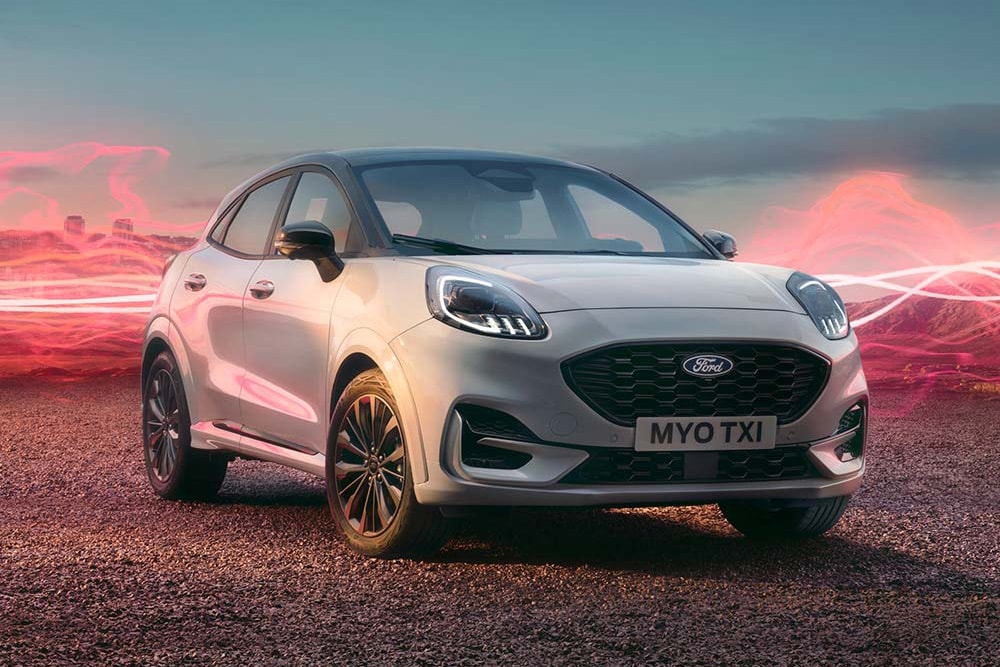 Modelul Ford Puma Sound Edition alb, parcat, cu grafică cu unde sonore roșii în fundal.