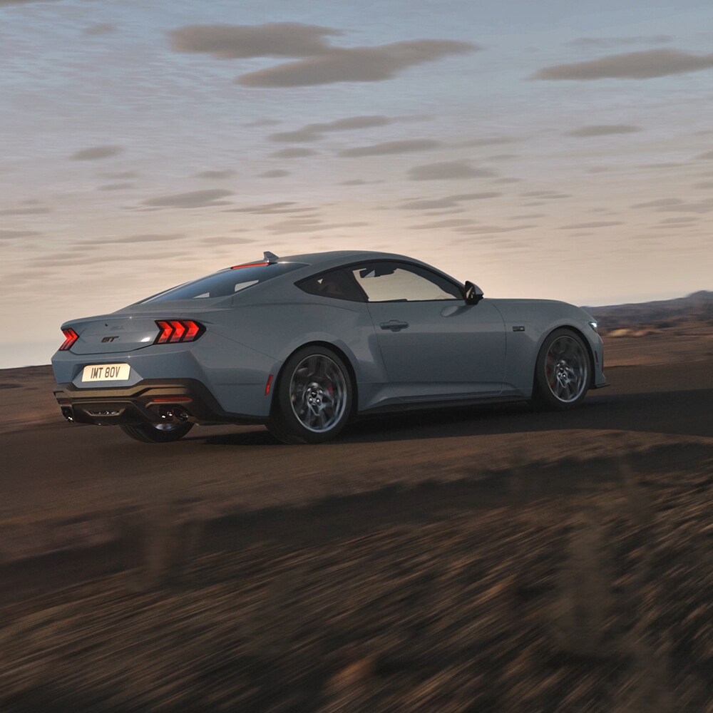 Un model Ford Mustang albastru luând un viraj