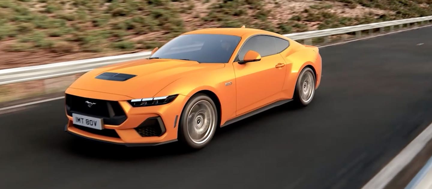 Ford Mustang GT Fastback în culoarea Orange Fury rulând pe un drum montan