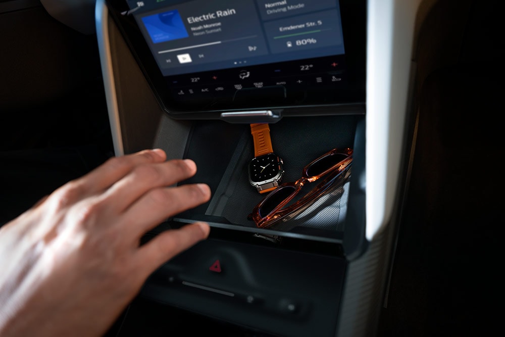 O mână se întinde spre compartimentul My Private Locker din modelul Ford Capri®, arătând un ceas și o pereche de ochelari de soare în interior.