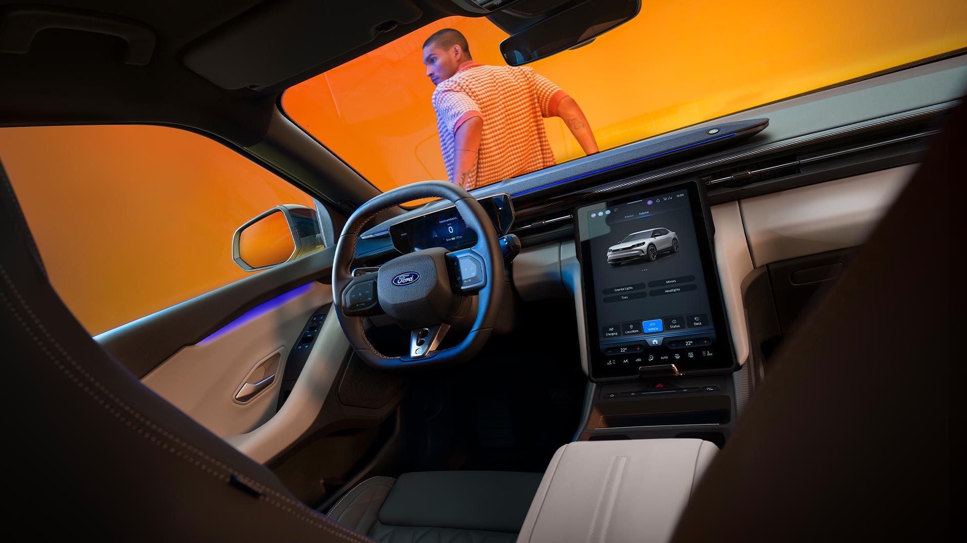 Interiorul unui model Ford Capri® în timp ce este parcat într-un studio foto galben. Un bărbat se sprijină pe partea din față a mașinii.