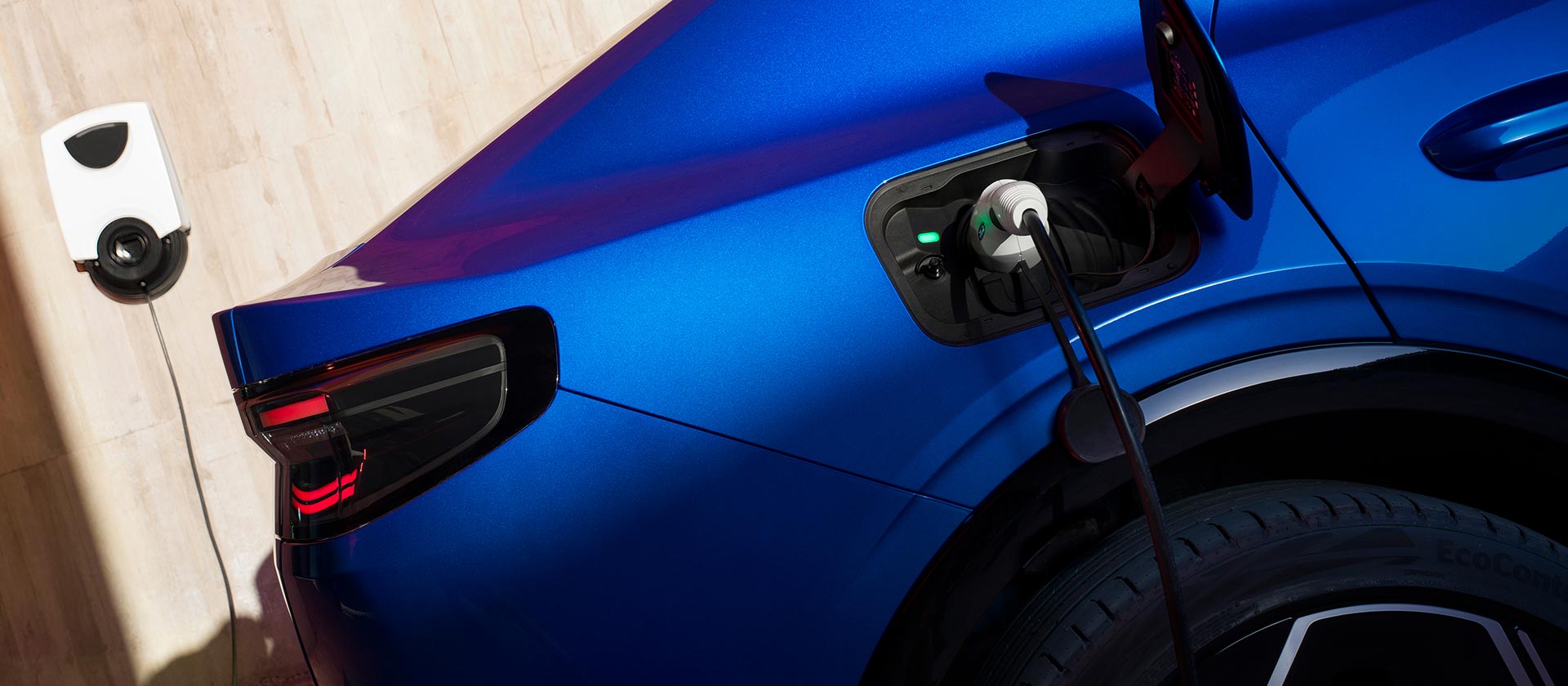 Prim-plan al portului încărcătorului electric Ford Capri®, conectat la un încărcător EV de perete.