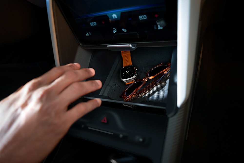 O mână se întinde spre compartimentul My Private Locker din modelul Ford Capri®, arătând un ceas și o pereche de ochelari de soare în interior.