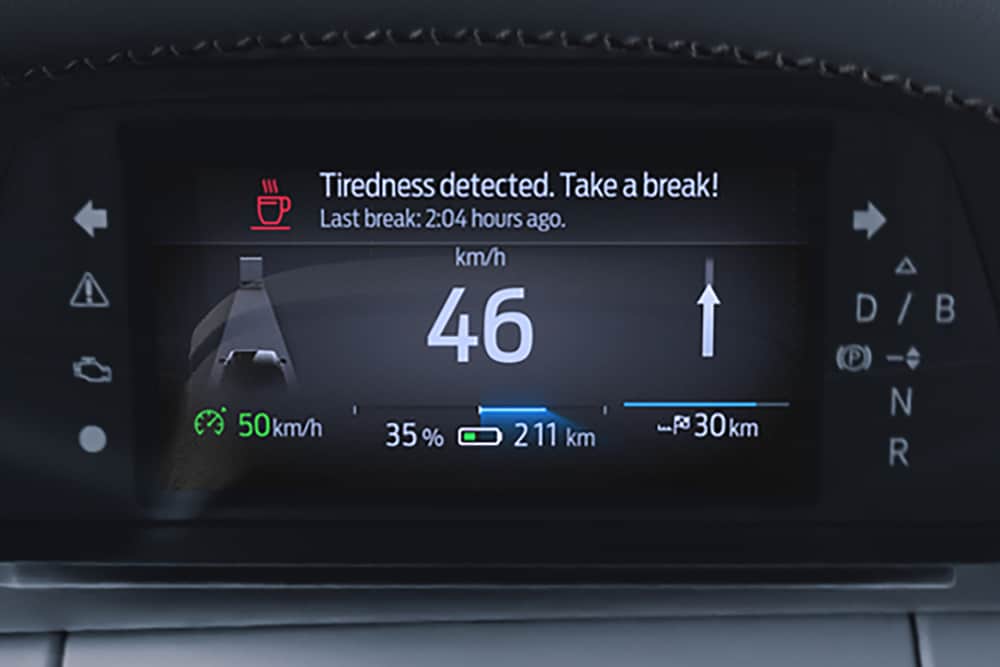 Panoul de instrumente digital al modelului Ford Capri® care afișează viteza mașinii și un mesaj de avertizare a șoferului prin care i se recomandă o pauză.