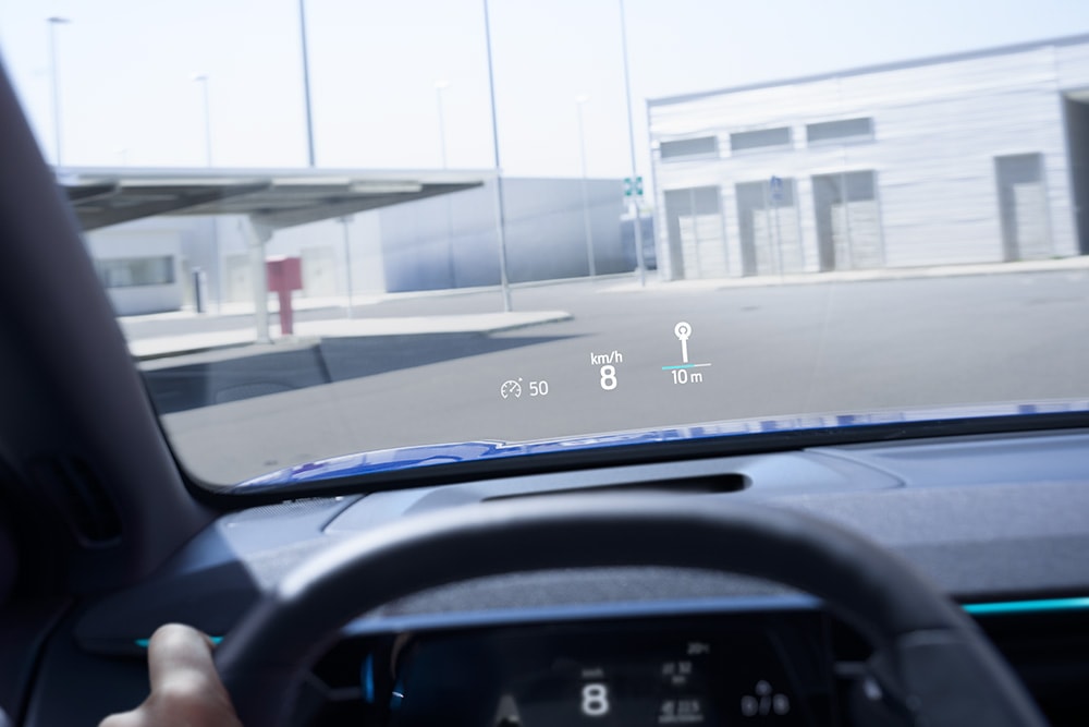 Interiorul unui vehicul Ford, cu un prim-plan al volanului și vedere prin parbriz.