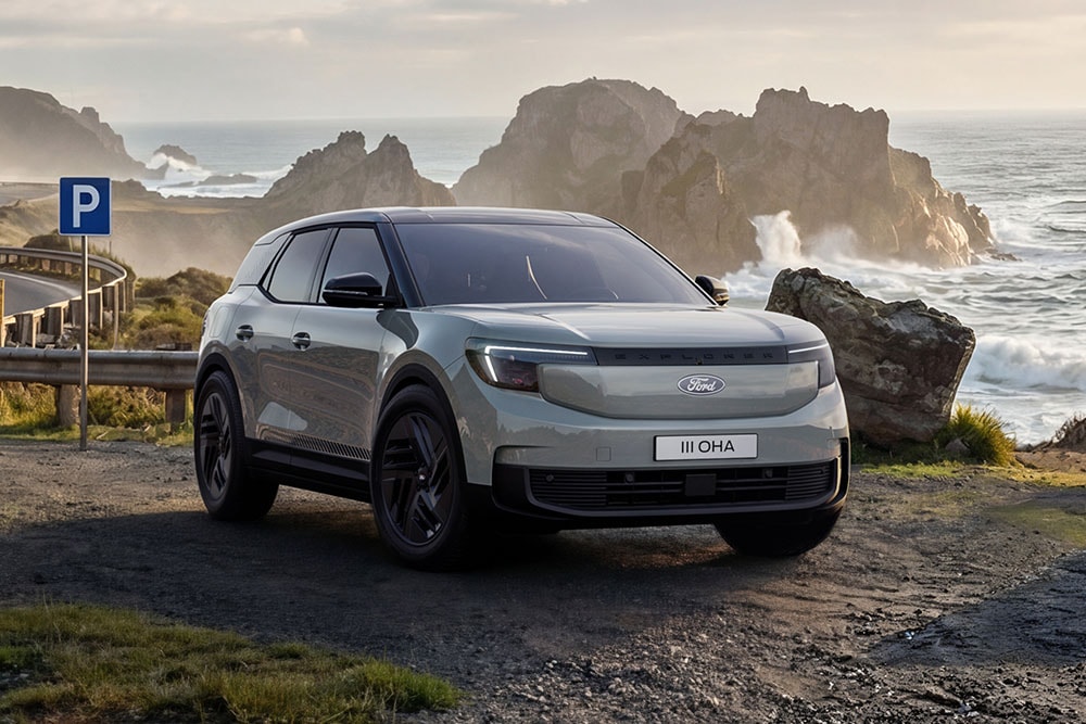 Ford Explorer® Collection argintiu parcat pe un drum lângă un țărm stâncos.