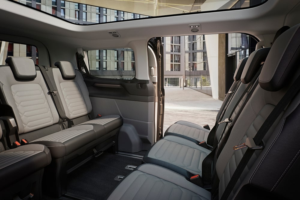 Scaune flexibile cu trei rânduri în interiorul modelului Ford Tourneo Custom pentru transport persoane.
