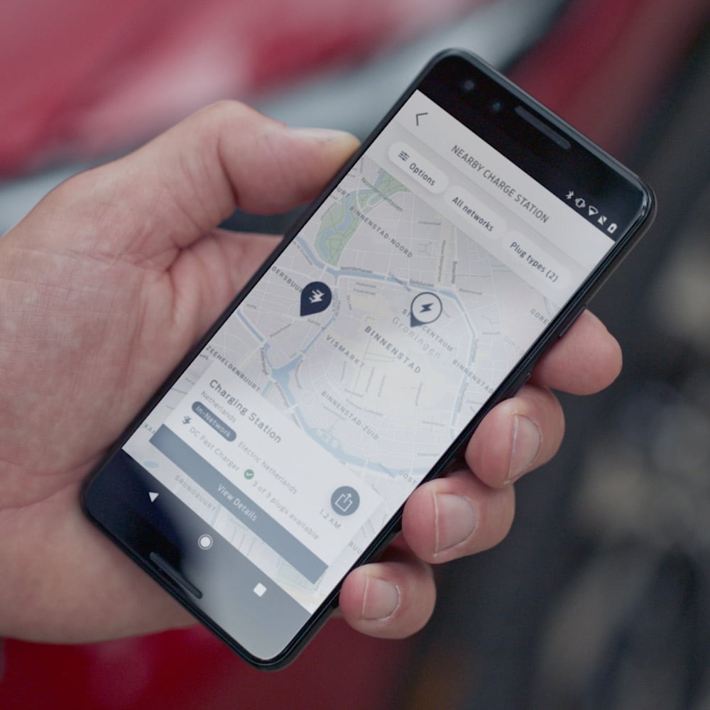 Persoana care foloseste aplicatia FordPass, pe un smartphone