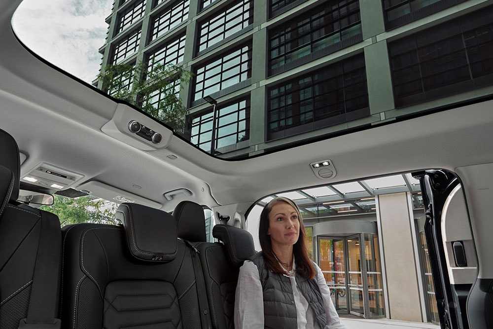 Person looking up the panorama roof of the All-New Tourneo Custom