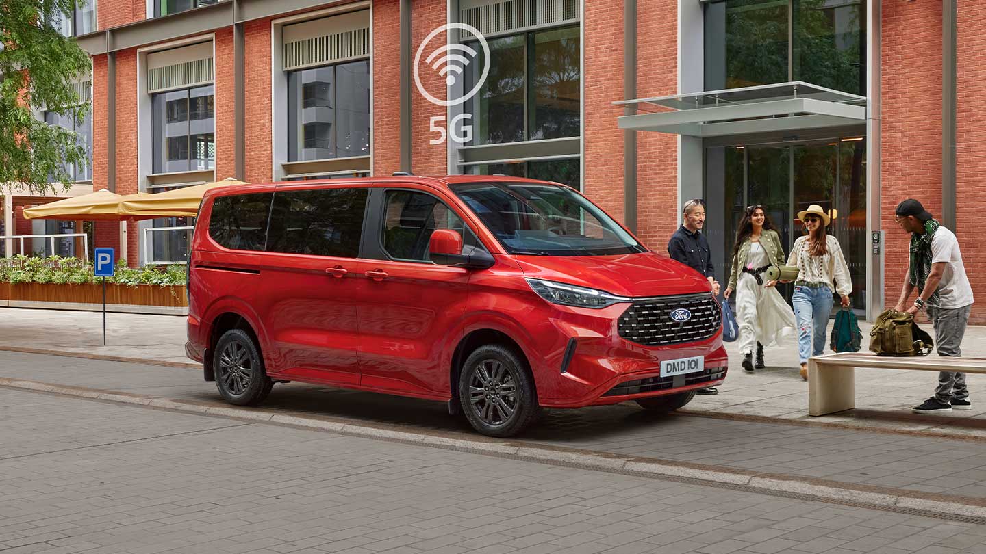 Red All-New Tourneo Custom parked with people around it