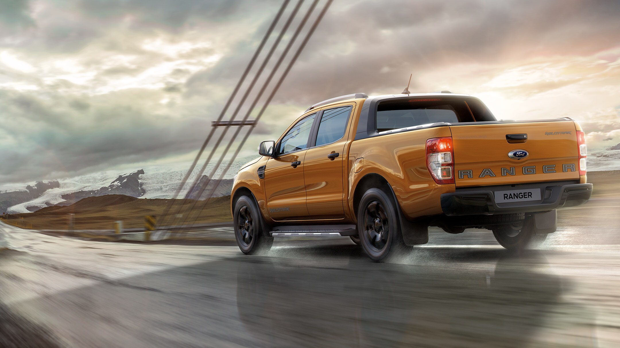 Orange Ford Ranger rear view driving on wet road