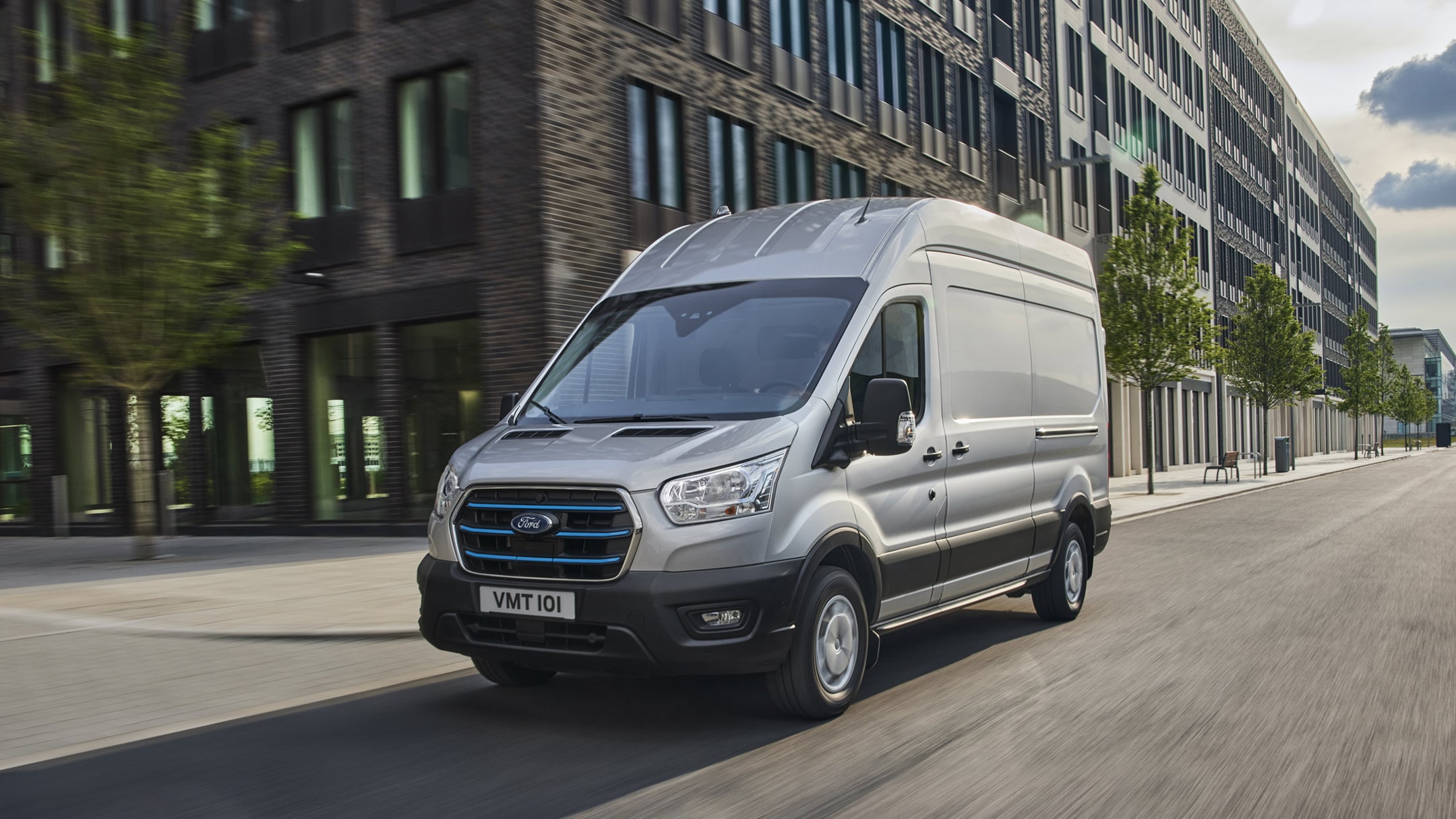 Noul Ford E-Transit conducând prin oraș 3/4 vedere frontală