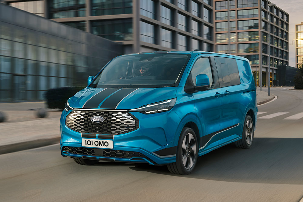 Ford E-Transit Custom  Dublă Cabină in Van Sport albastru deplasându-se pe o stradă din oraș.