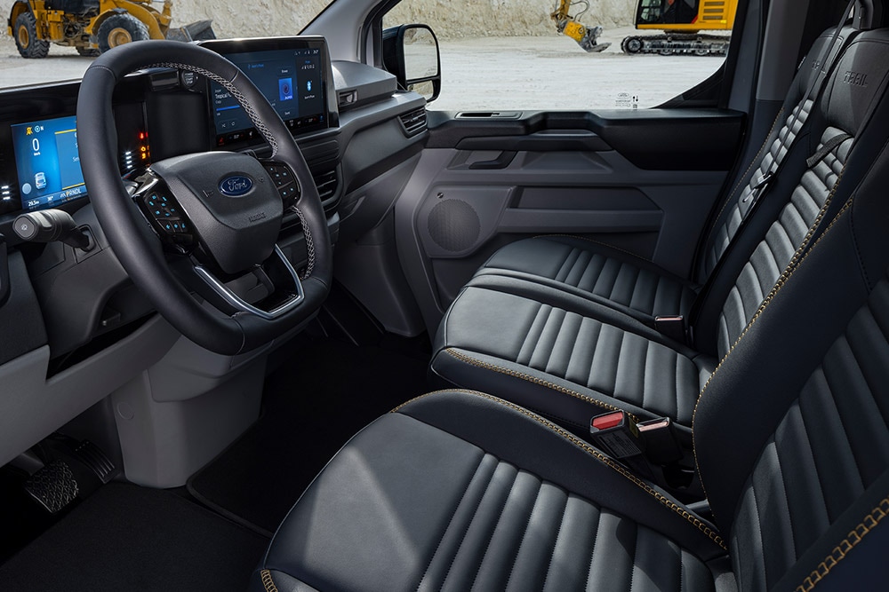Interiorul unui furgon electric Ford E-Transit Custom Sport cu scaune cu tapițerie neagra cu inserții galbene.