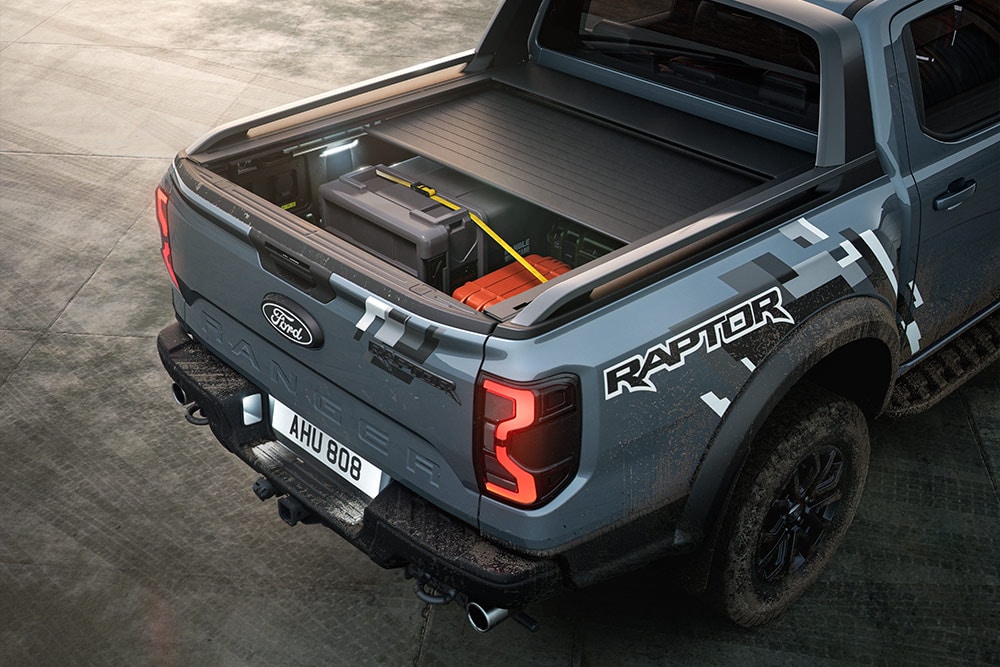 Vedere din spate a unui Ranger Raptor culoare Meteor Grey , parcat, în care se vede ruloul acționat electric.