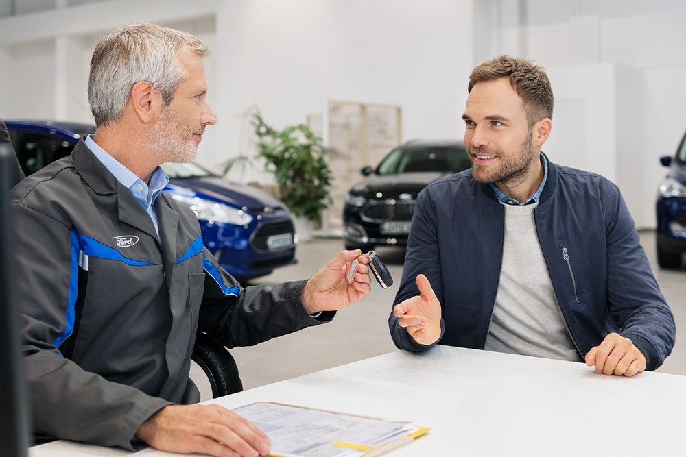 Two people discussing in Ford dealership