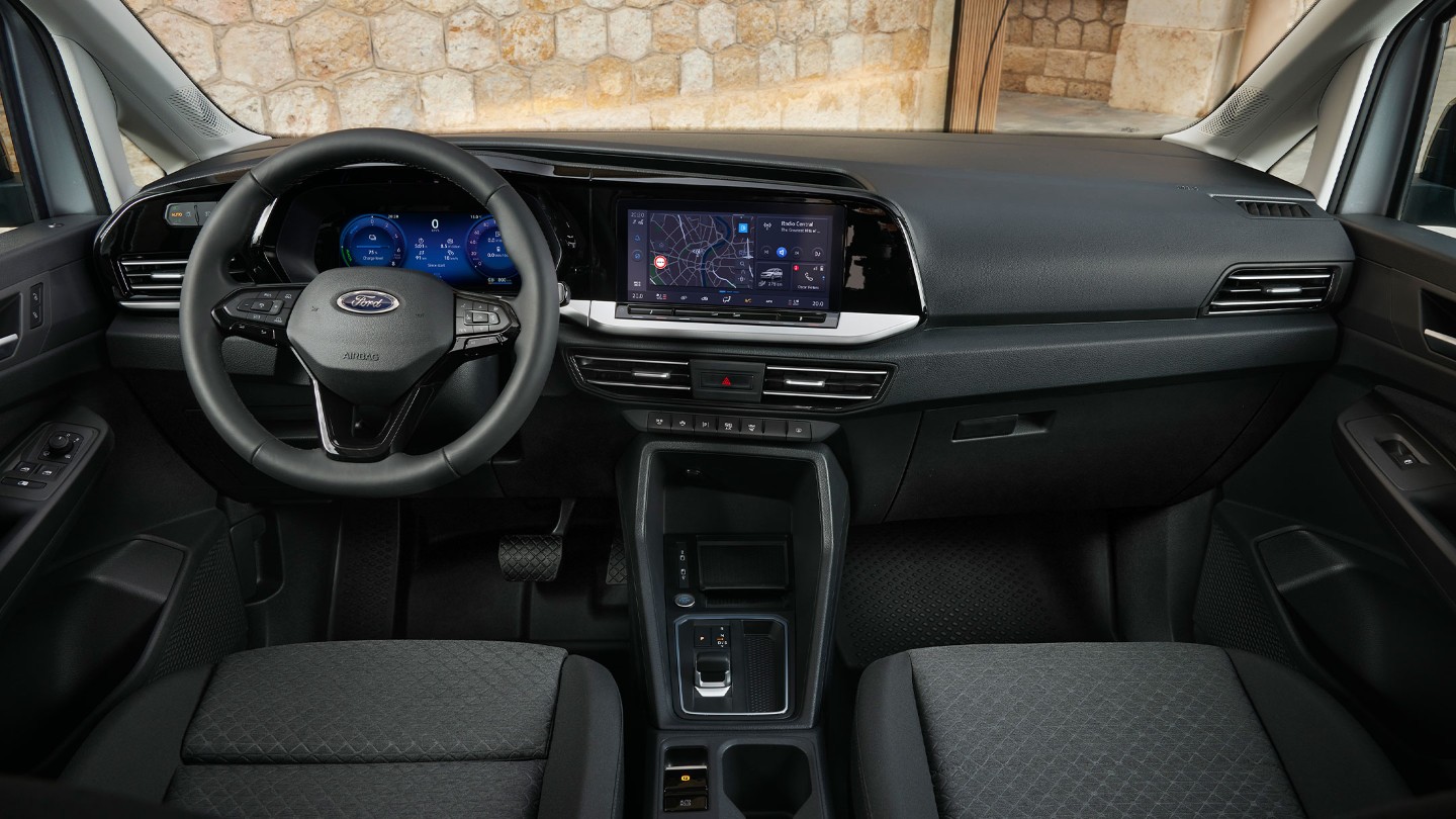 Interior cu partea din față a noului Ford Transit Connect care prezintă volanul, panoul de instrumente digital și ecranul tactil de 10”.