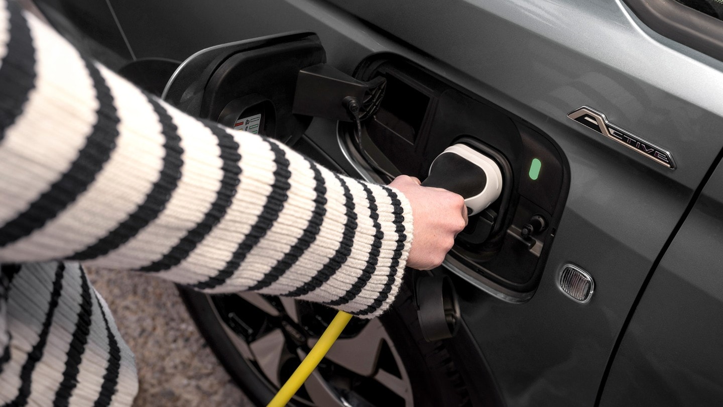 Cablu de încărcare conectat la portul unui Ford Tourneo Connect în culoarea Boundless Blue.