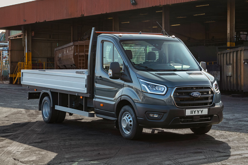 Ford Transit autoșasiu cu cabină parcat pe o proprietate industrială. 