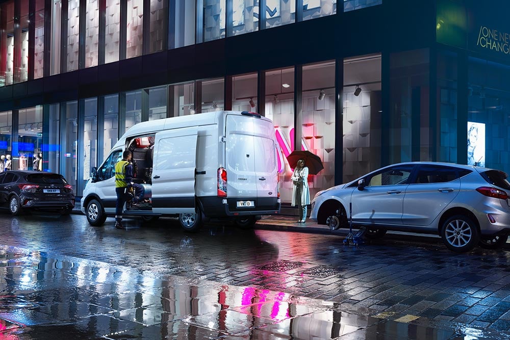 Ford Transit Van recovery vehicle parked in a city at night.