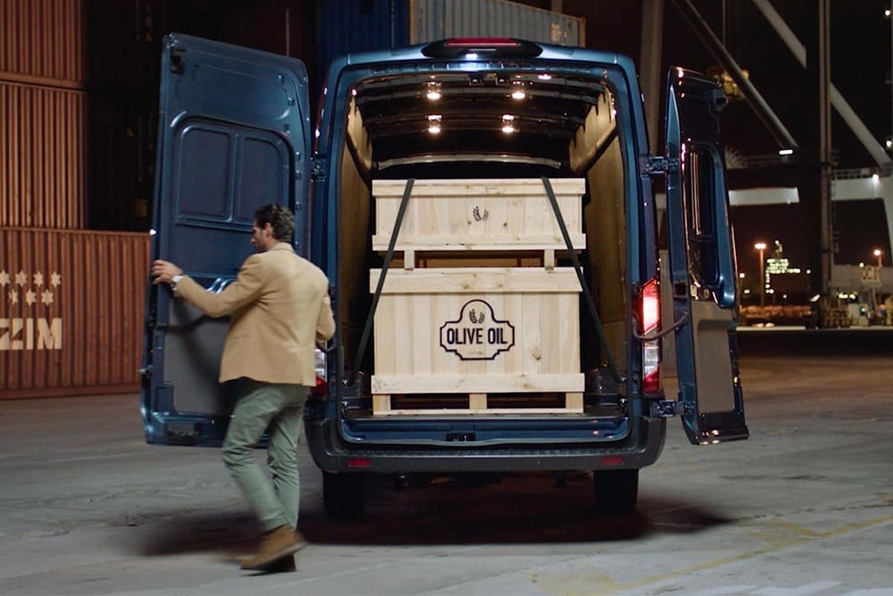 Furgonetă Ford Transit cu ușile din spate deschise și încărcătură în interior.
