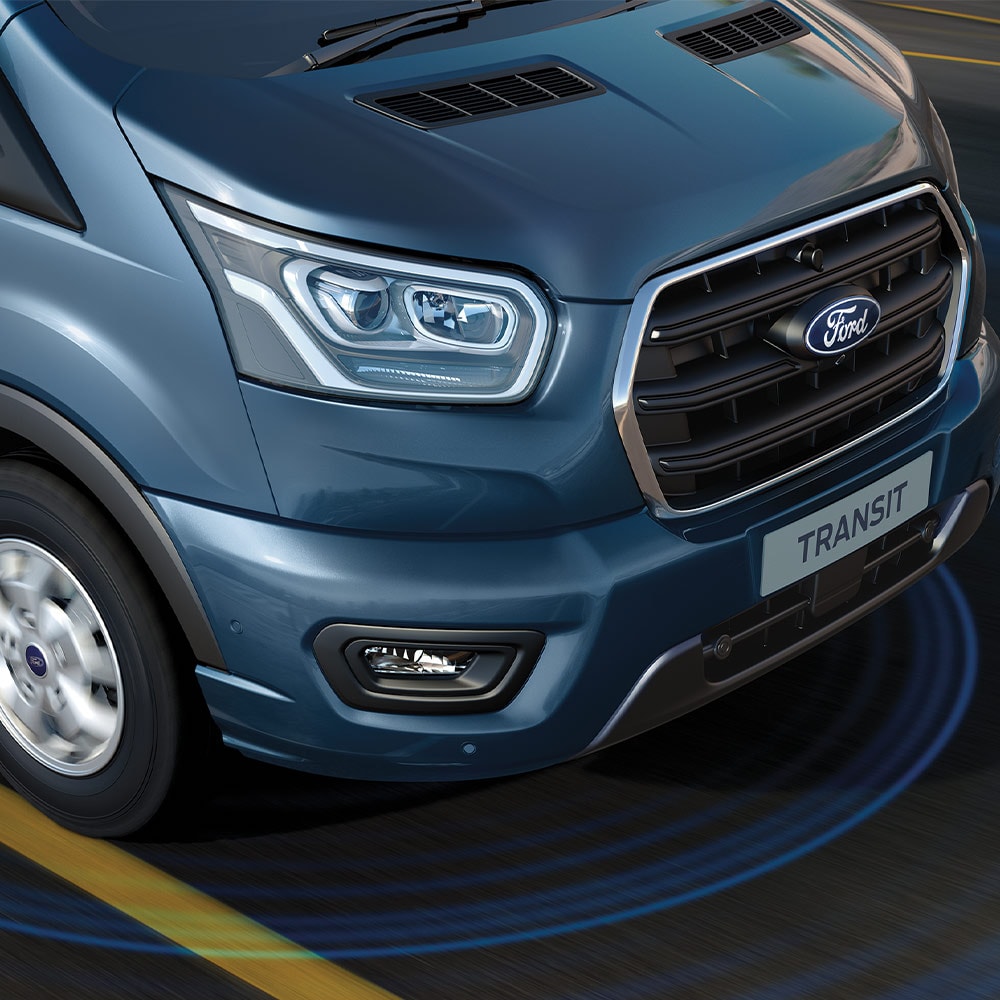 Furgonetă Ford Transit albastră cu linii albastre pe șosea care indică utilizarea sistemelor avansate de asistență a șoferului.