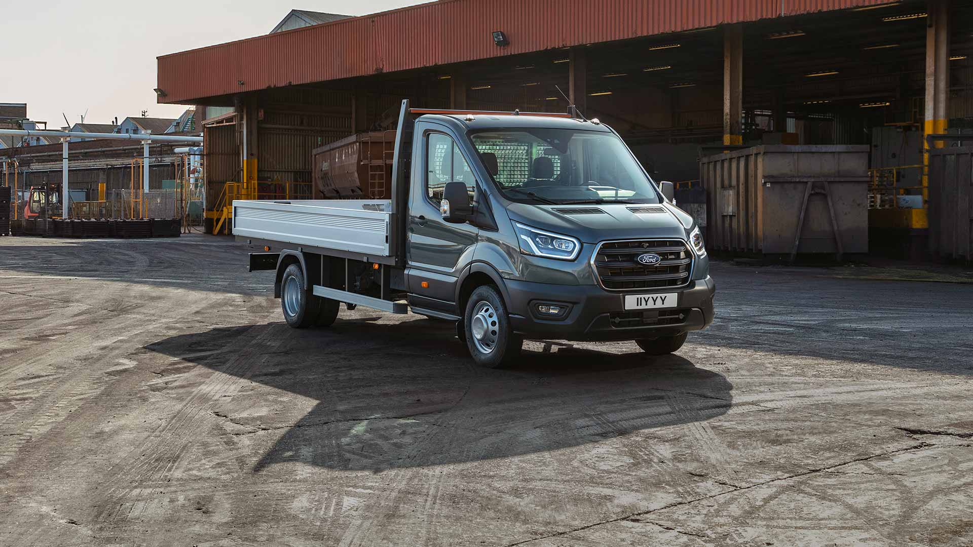 Ford Transit autoșasiu cu cabină parcat pe o proprietate industrială. 