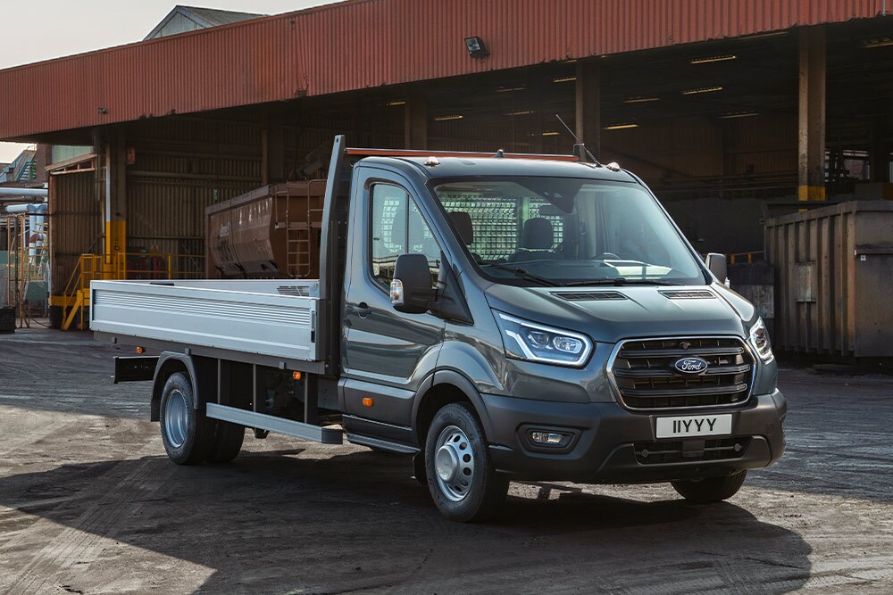 Ford Transit Autoșasiu cu Cabină Simplă parcat pe o proprietate industrială. 
