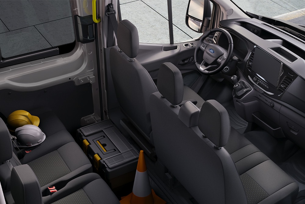 Interiorul unui Ford Transit cu cabină dublă cu două rânduri de scaune.
