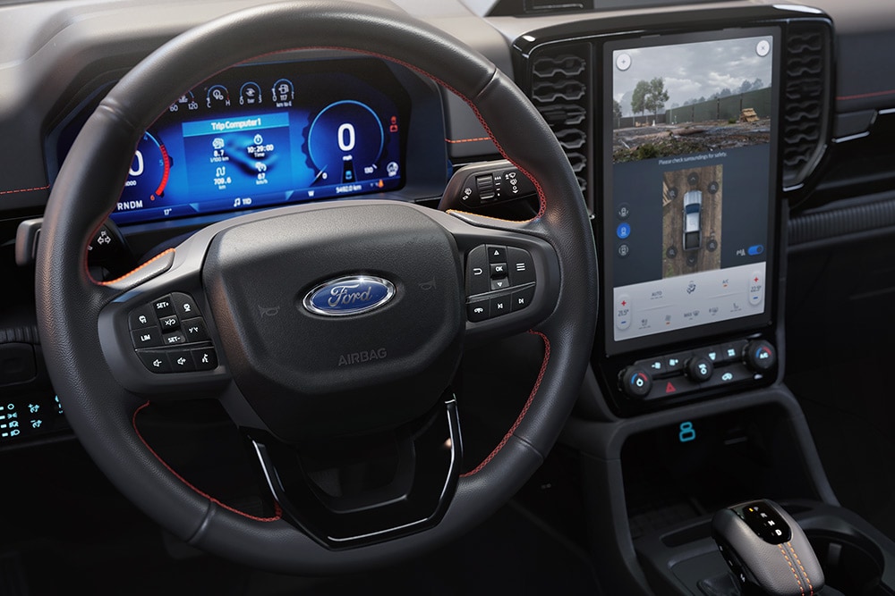 Vedere interioară a unui Ford Ranger Wildtrak prezentând volanul, ecranul tactil central SYNC™ 4 de 12 inch [31 cm].