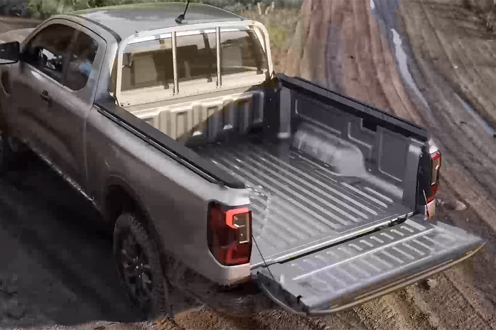 Silver Ford Ranger XLT cu cabină extinsă parcat pe o suprafață noroioasă, cu hayonul deschis, privit de sus.