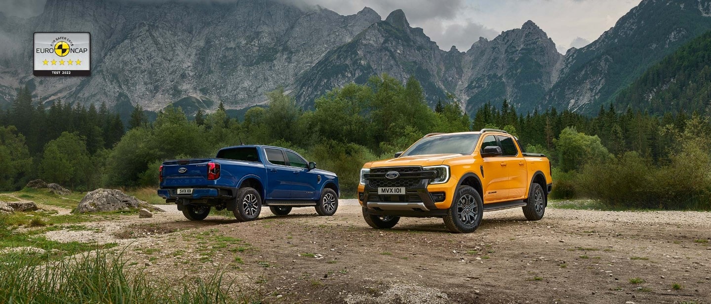 Ford Ranger portocaliu vedere din față 3/4, pe pietriș în fața unui Ford Ranger albastru, vedere din spate 3/4