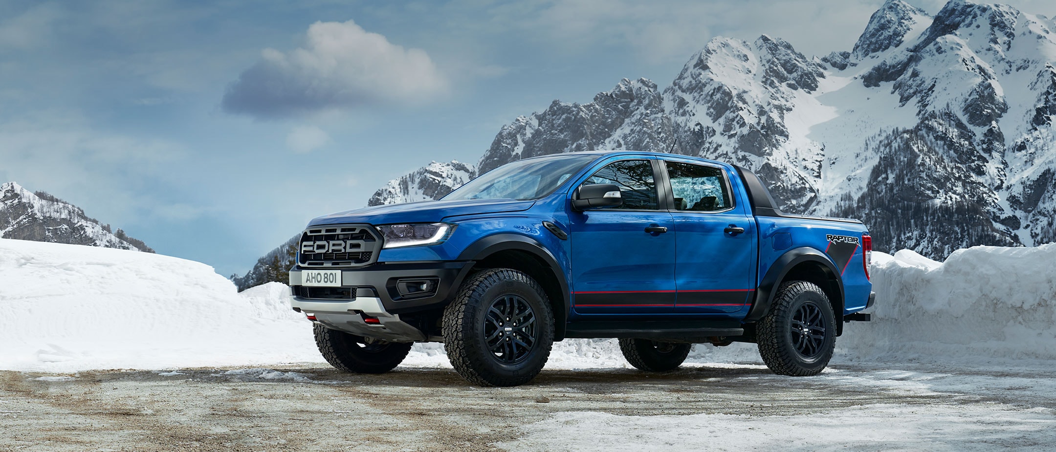 Blue Ford Ranger Raptor parked on snowy mountains
